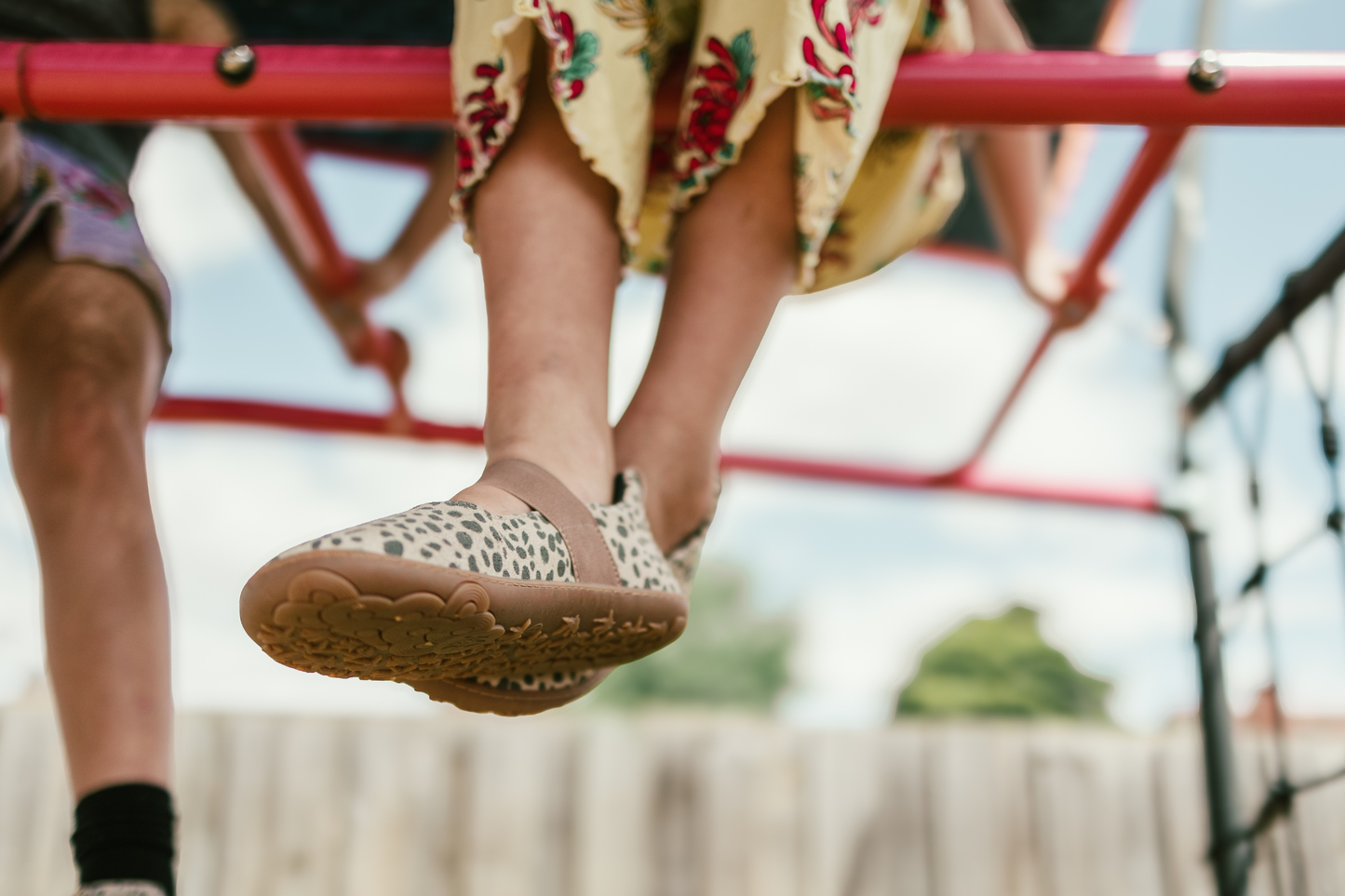 Child's feet wearing cheetah print shoes on a playground.