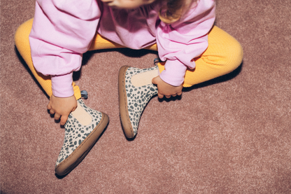 CHILD SITTING IN CHEETAH BOOTS, IMAGE FROM ABOVE