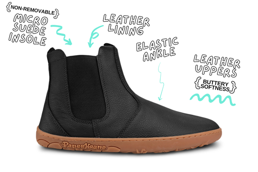 Side view of one black tumbled leather PaperKrane chelsea boot. The sole is gum with the word "PaperKrane" on the side. The background is white with words around the boot describing the features.