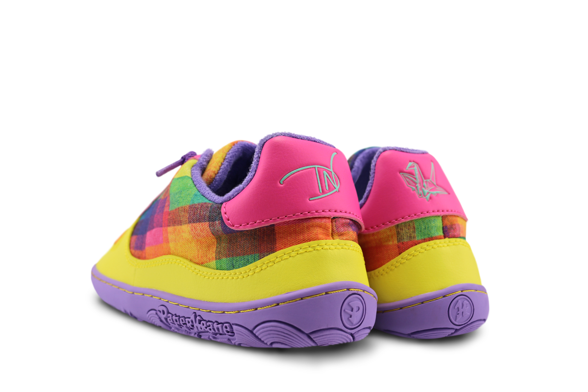 Colourful children's barefoot sneakers by PaperKrane, viewed from the back, with a checkered pattern by Di Nowinski on a white background