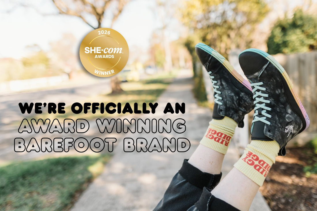 Photograph of PaperKrane 'Holey Skit' style tall boots taken in an outdoor setting, with gold medal she-com award winner logo, with text that reads 'we're officially an award winning barefoot brand'
