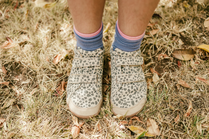 Children's cheetah print foot-shaped velcro sneakers and socks on grassy ground