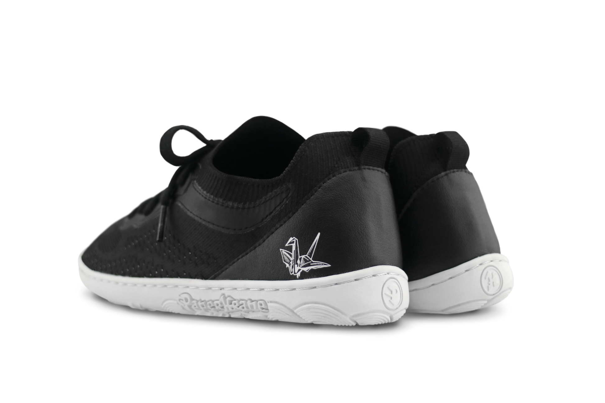Black low sneaker shoes with white sole on a white background