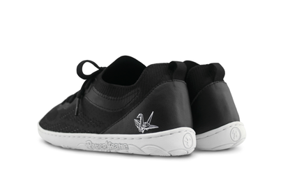 Black low sneaker shoes with white sole on a white background
