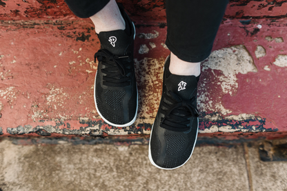 PAPERKRANE AKTIVE LOW SNEAKER FROM ABOVE SITTING ON A RED PAINTED STEP