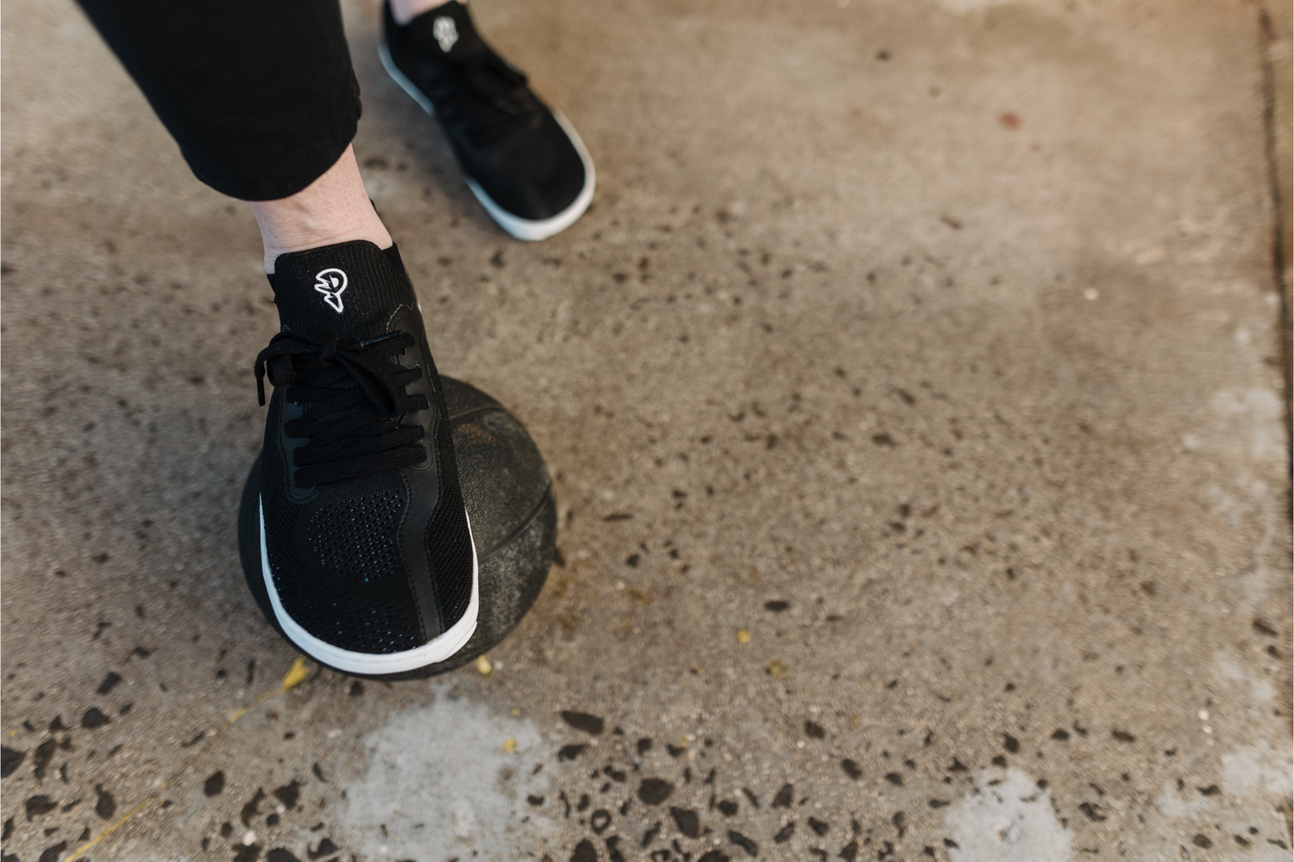 Black barefoot athletic shoes on a concrete surface