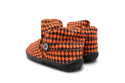 A pair of slip-on PaperKrane shoes for toddlers and kids, featuring a vibrant orange and black diamond pattern on the fabric uppers, with flexible black rubber soles.