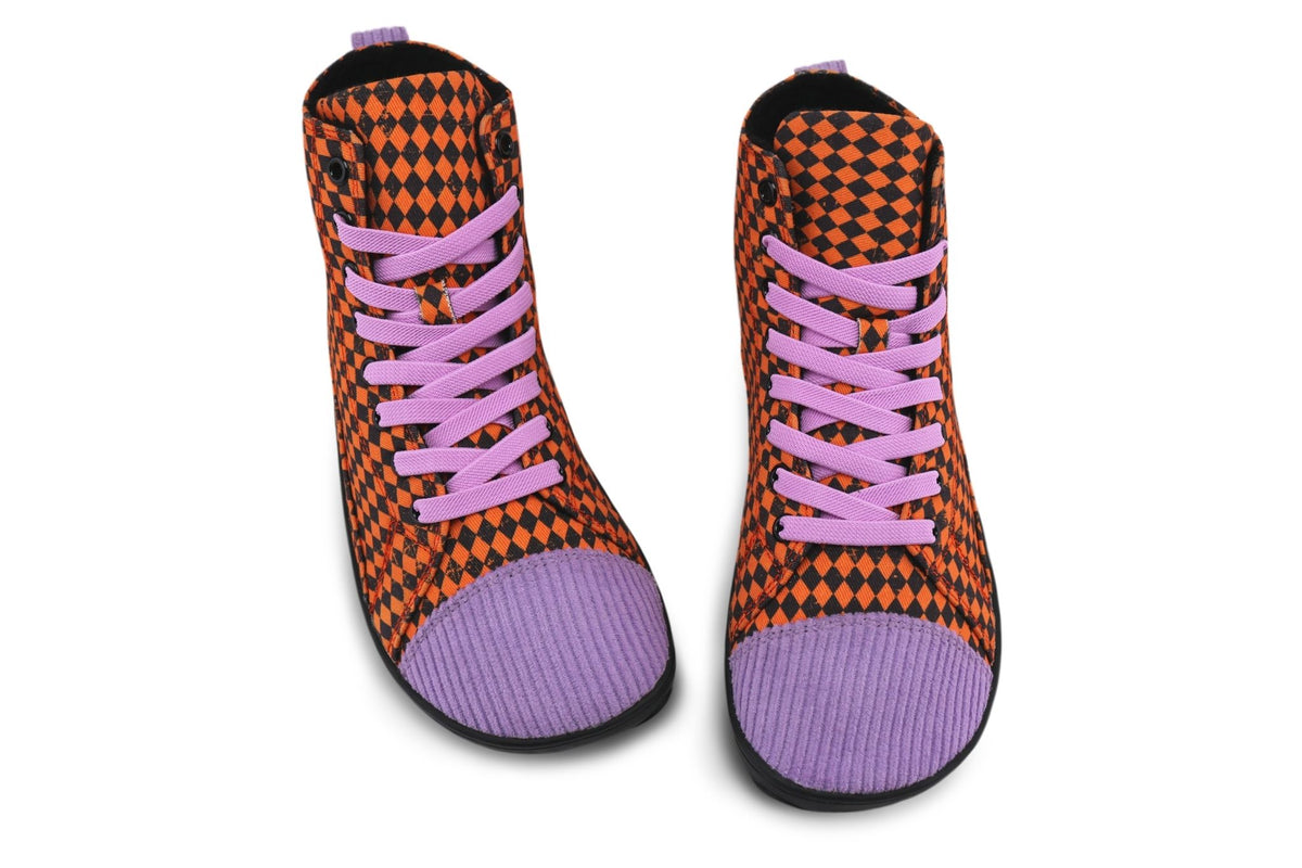 A pair of PaperKrane foot-shaped tall boots with orange and black argyle printed cotton uppers, and purple corduroy toe and heel, on a black rubber sole can be seen from above on a white background. 