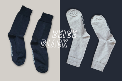 Black and beige merino socks from Roam Barefoot, they're made in New Zealand, and are on a black and beige background. 
