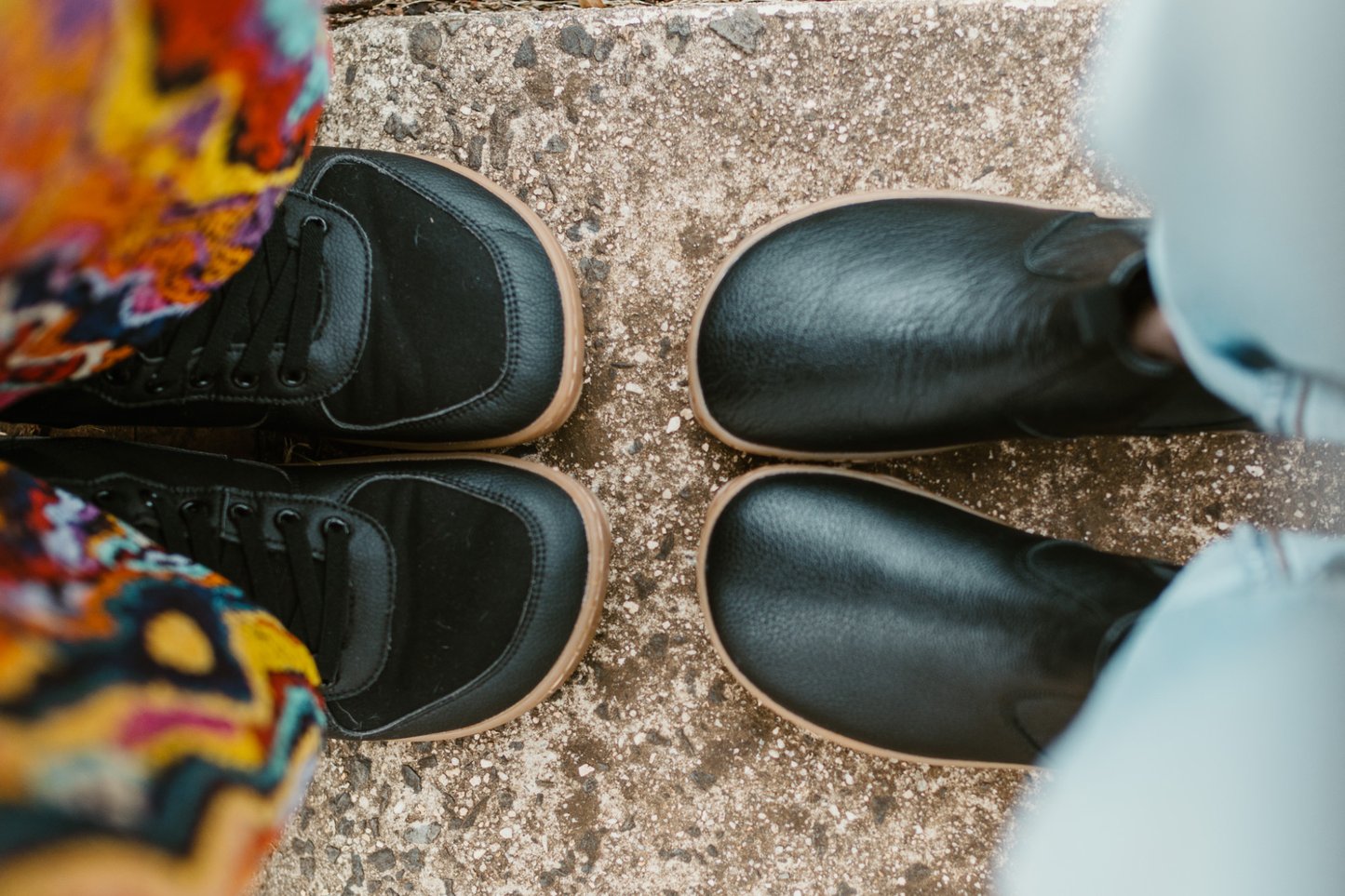 Two people face each other in SNUGG boots and BLACK GUM boots that both are online. PaperKrane boots are footshaped and foot-friendly. The SNUGG on the left are vegan materials and the BLACK GUM are a leather chelsea boot, made with soft tumbled leather. 