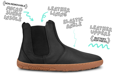 Side view of one black tumbled leather PaperKrane chelsea boot. The sole is gum with the word "PaperKrane" on the side. The background is white with words around the boot describing the features. 