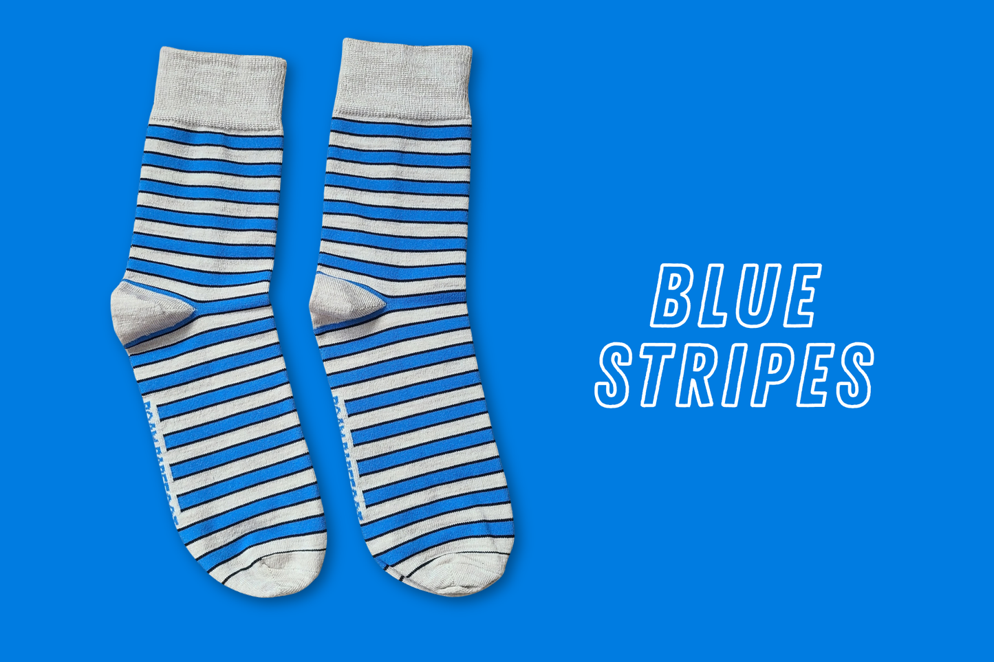 Pair of Roam Barefoot New Zealand made merino socks with blue and beige/grey stripes on a blue background