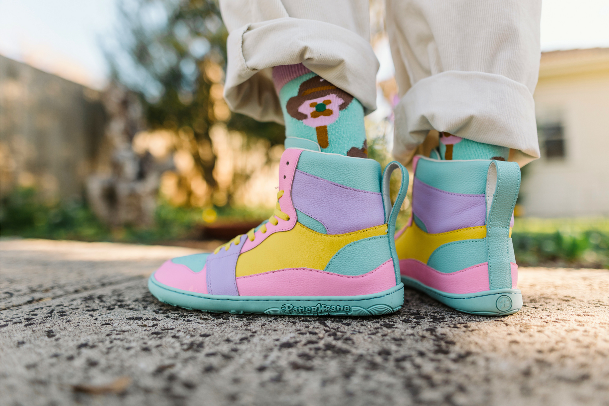 Colourful high-top sneakers worn outdoors on a blurred background