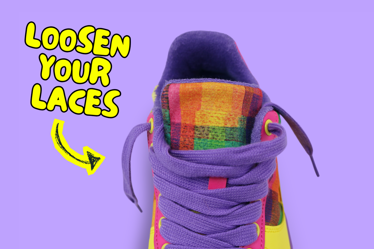 A close-up of a colourful sneaker with purple laces and a multicolour plaid tongue, shown on a lavender background with the text 'LOOSEN YOUR LACES' and a yellow arrow. It's best to loosen this pair to reduce strain on the lightweight cotton fabric.