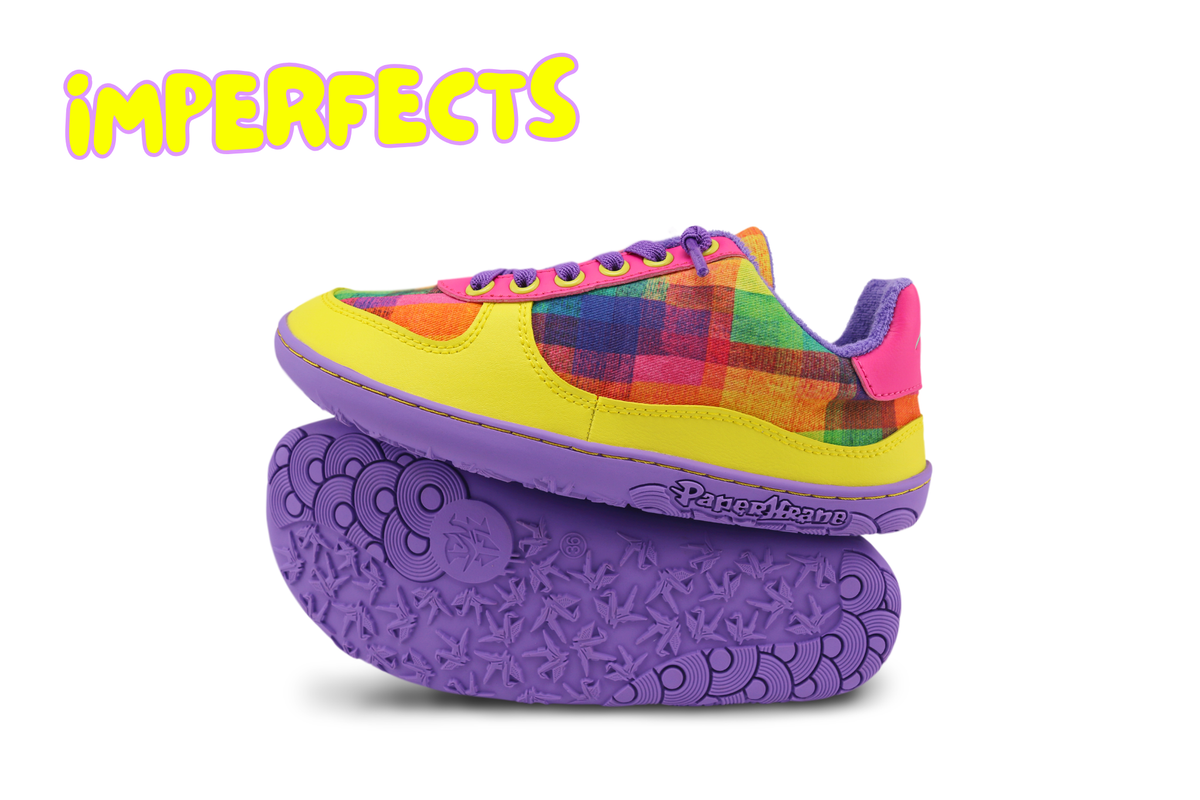 Close-up of the side of a low-top sneaker with a multicolour plaid fabric upper and hot pink suede heel counter, purple laces and sole. The word "IMPERFECTS" is written up in the top left corner. Please read the product description to see why. 