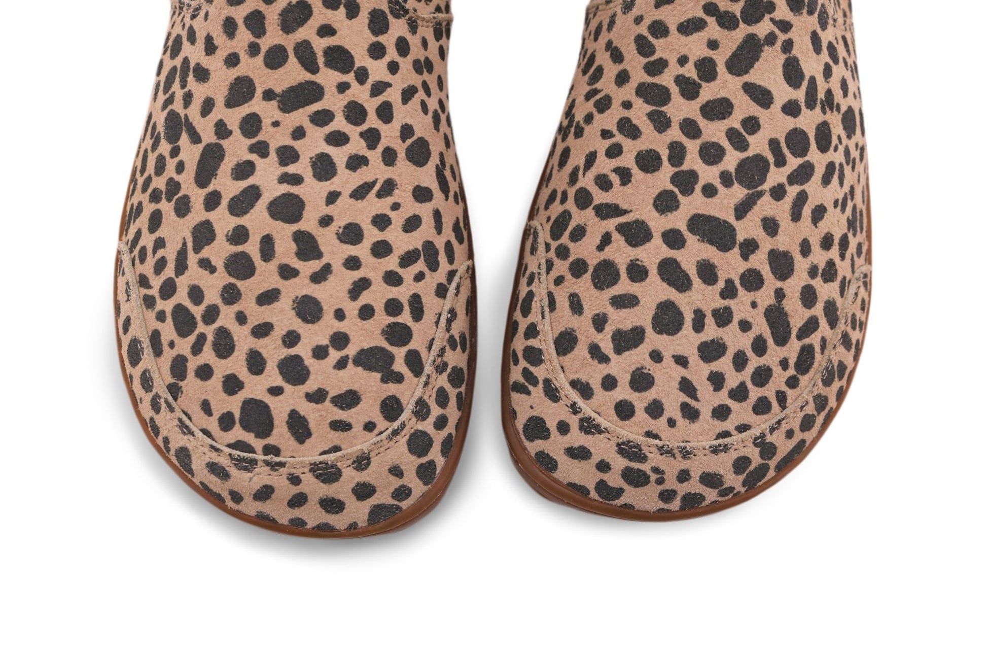 A view from above of the toe box of a pair of foot-shaped cheetah print chelsea boots from PaperKrane. The suede is beige and charcoal, with gum rubber soles on a white background.