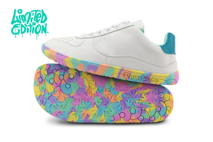 A pair of low-top PaperKrane barefoot sneakers shown on a white background, with one shoe standing upright and the other lying on its side to display the colorful sole. The upper is white with a teal heel tab, and the sole features a vibrant multicolour psychedelic pattern.