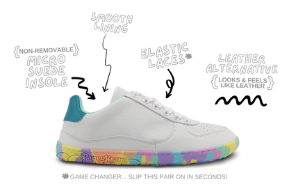 A white low-top barefoot PaperKrane sneaker with a colourful rainbow gradient sole and teal heel, shown with hand-drawn callouts highlighting features like smooth lining, elastic laces, non-removable micro suede insole, and leather alternative.