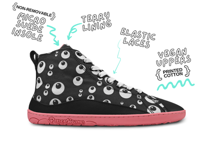 Side view of black PaperKrane barefoot high top with cartoon eyeballs, this vegan boot has white elastic laces, and salmon coloured rubber sole. The boot is on a white background shoe details. 