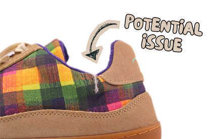 Close-up of the heel and side of a low-top sneaker with a multicolour plaid fabric upper and tan suede heel counter. A hand-drawn arrow points to a tear on the ankle area with the text 'POTENTIAL ISSUE' on a white background.