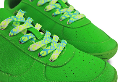 Close-up of green sneakers with green and aqua leopard laces on a white background.