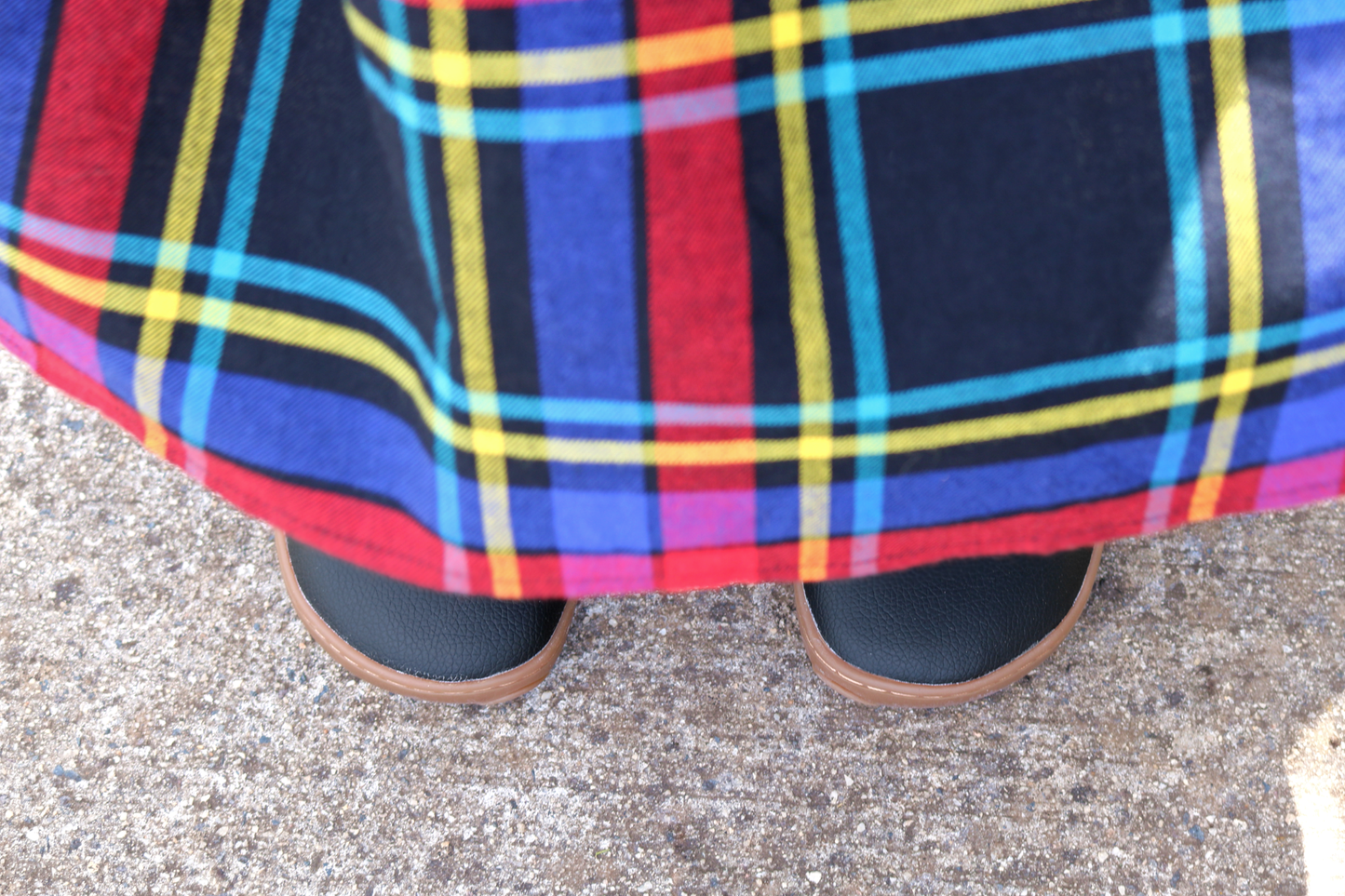 Black and gum mj toes peeking out from under a tartan skirt