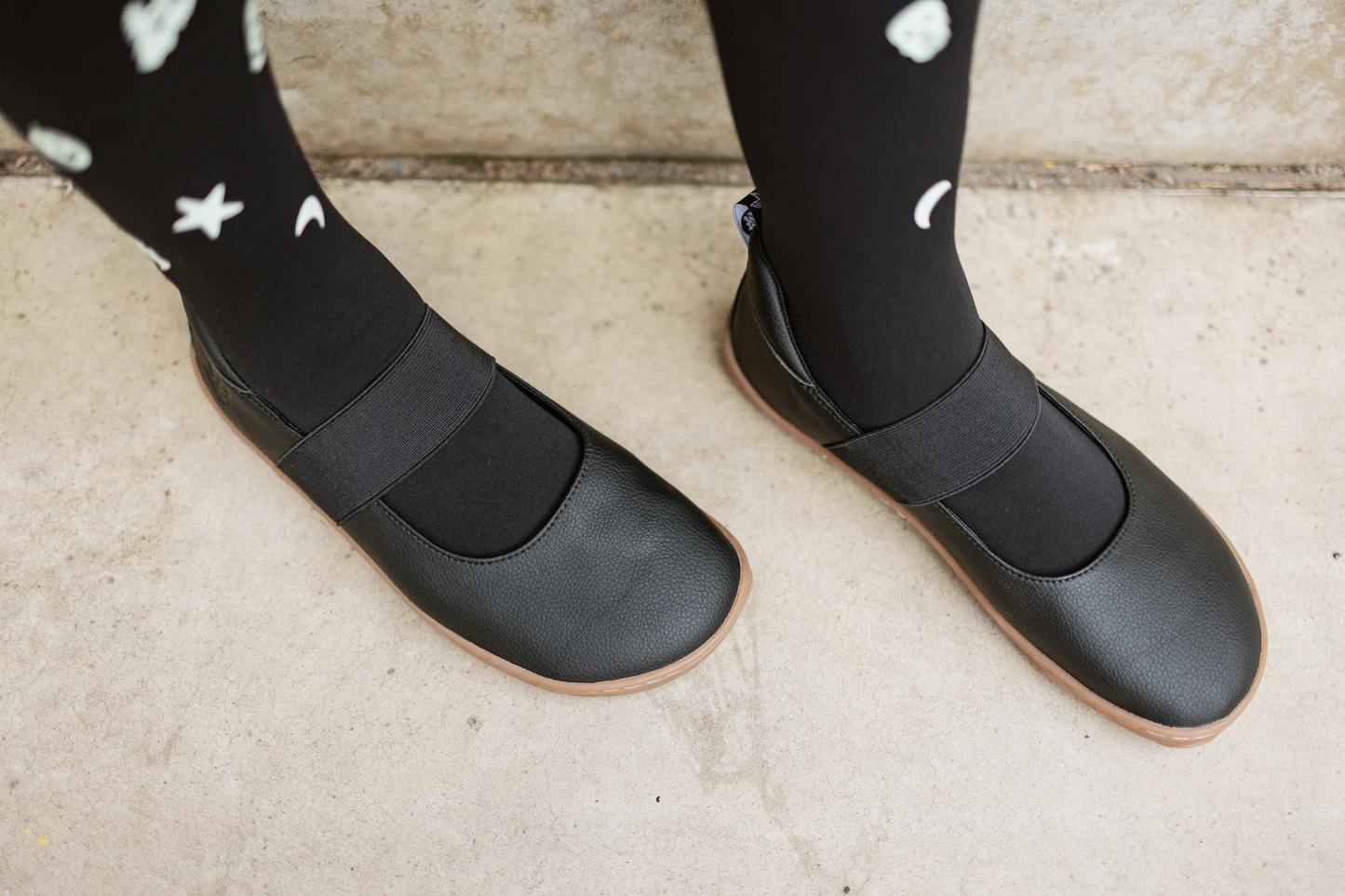 Angled above view of black vegan mjs on a gum sole, on concrete