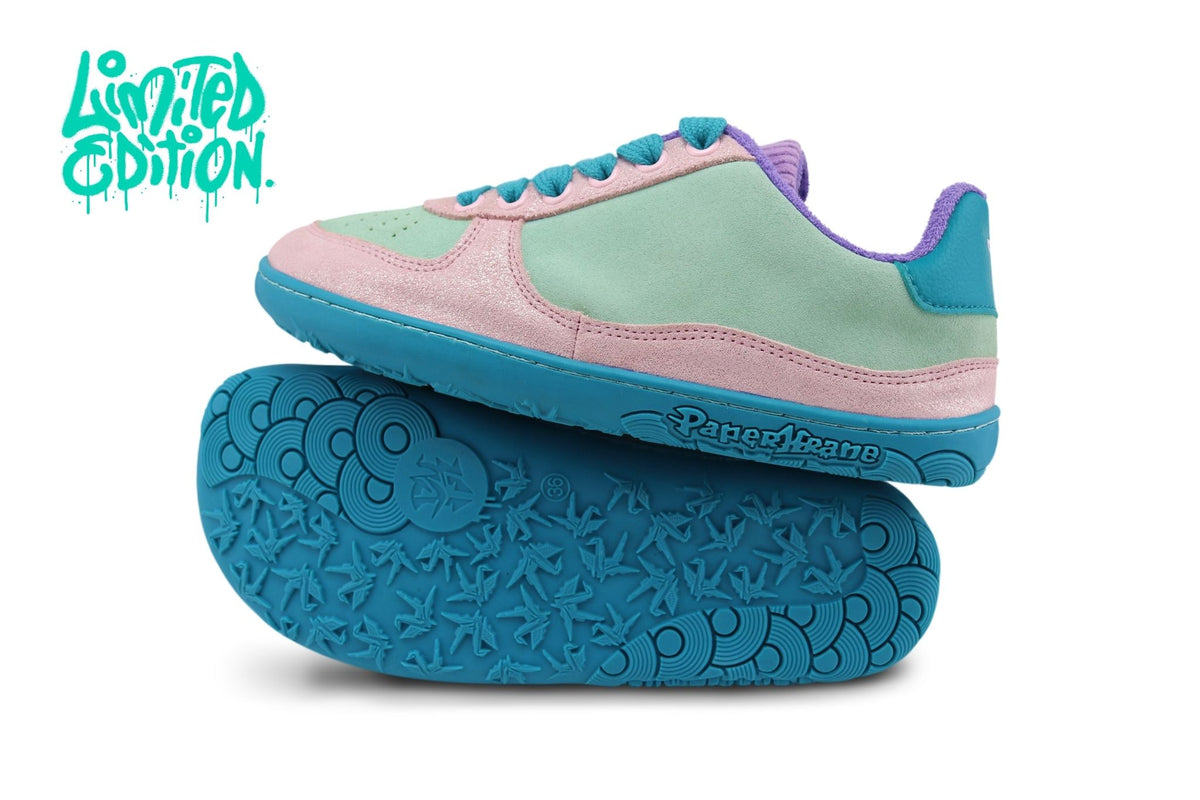 A pair of retro-style low-top barefoot sneakers shown on a white background, with one shoe standing upright and the other lying flat to display the sole. The shoes feature pastel pink and mint green leather panels, bright teal soles and laces, and a small purple corduroy accent on the collar.