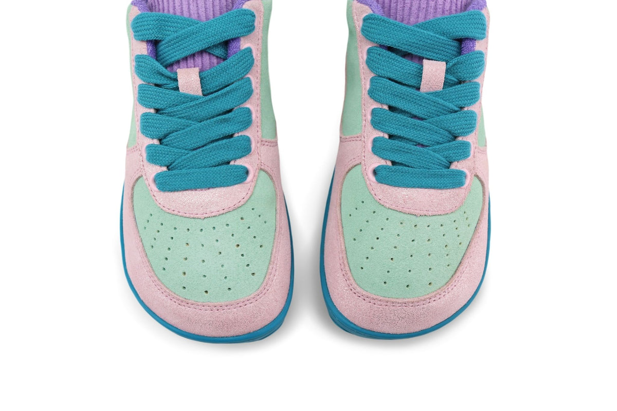 A pair of foot-shaped PaperKrane low sneakers shown from the front and top, featuring pastel pink glitter leather, mint green perforated panels, teal blue laces and soles, and a purple corduroy tongue, set against a plain white background.