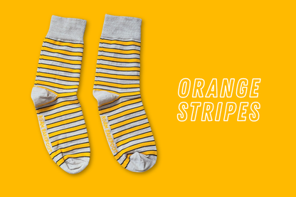 Pair of Roam Barefoot New Zealand made merino socks with light orange and beige/grey stripes on a light orange background