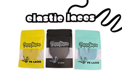 Three packages of 'PaperKrane' elastic laces in yellow, black, and blue on a white background.