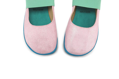 A pair of PaperKrane foot-shaped slip-on mary jane shoes in light pink shimmery suede leather with mint elastic straps, teal green interiors and teal-blue soles, shown from a top-down view on a white background.