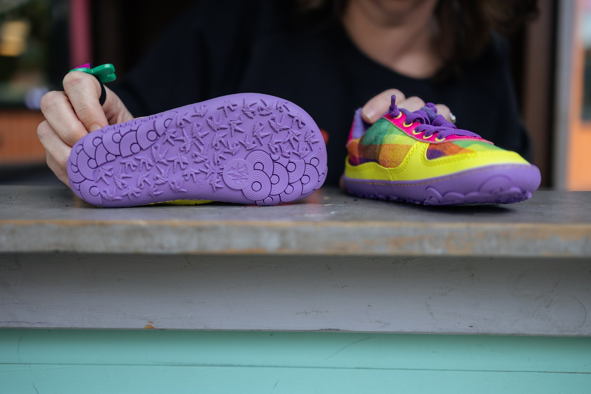 Colourful PaperKrane x Di Nowinski collab - foot-shaped sneakers with a purple sole and bright plaid print in a play house