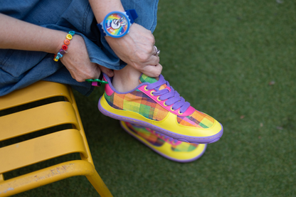 Di tries on her pair of Checkered joy barefoot sneakers. This collab with PaperKrane is so colourful! The ground is artifical grass, and Di sits on a yellow bench