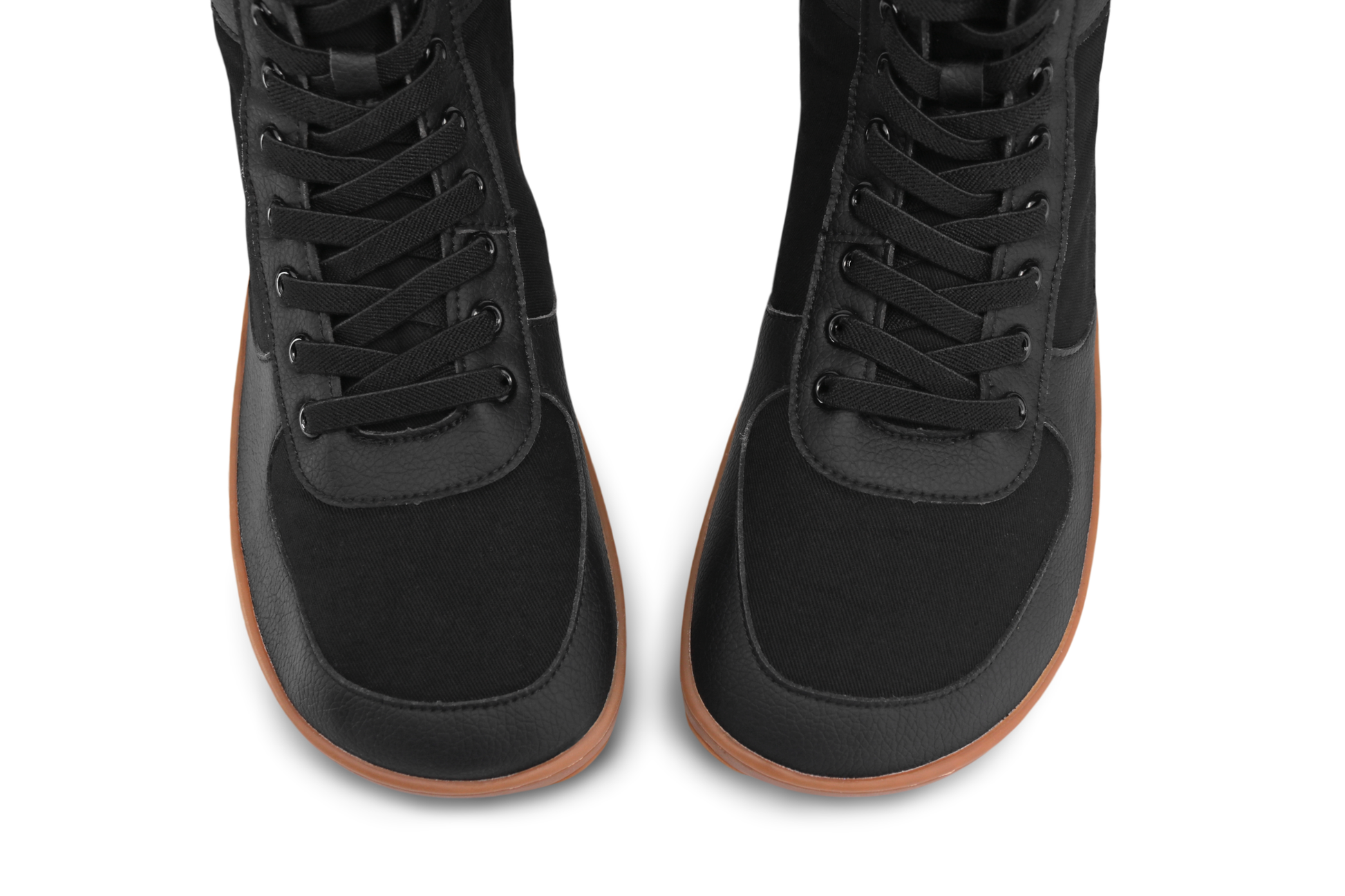 Above view of a pair of PaperKrane SNUGG boots. The boots are vegan materials with gum soles and elastic laces. This view shows you the foot-shaped soles and upper. 