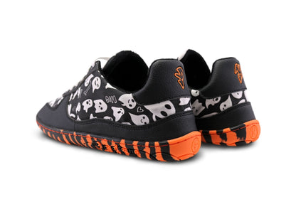 A pair of PaperKrane barefoot sneakers on a white backgroud. This pair has an orange and black striped sole with black vegan details on the upper and cotton printed with white ghosts on a black background. The letters P and K are on the back of the heel in orange. 