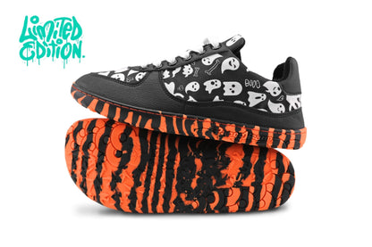 A pair of PaperKrane barefoot sneakers with orange and black striped rubber soles, black vegan leather, and white ghosts printed on cotton. They're on a white background with the words "Limited Edition" in the top left corner. 