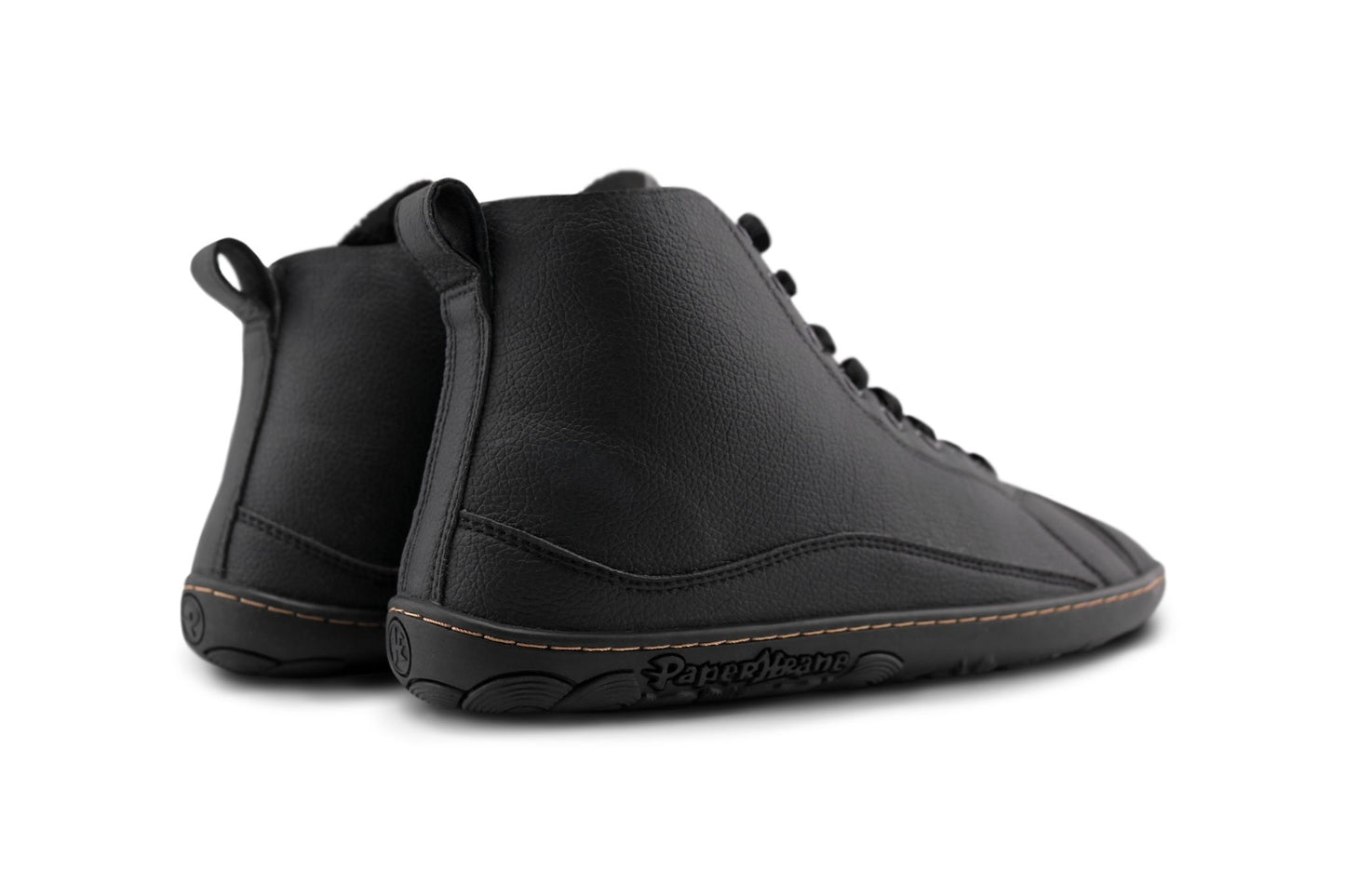 A pair of black vegan leather high-top lace-up shoes with a black barefoot sole, shown from a back angle on a white background.