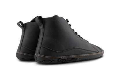 A pair of black vegan leather high-top lace-up shoes with a black barefoot sole, shown from a back angle on a white background.