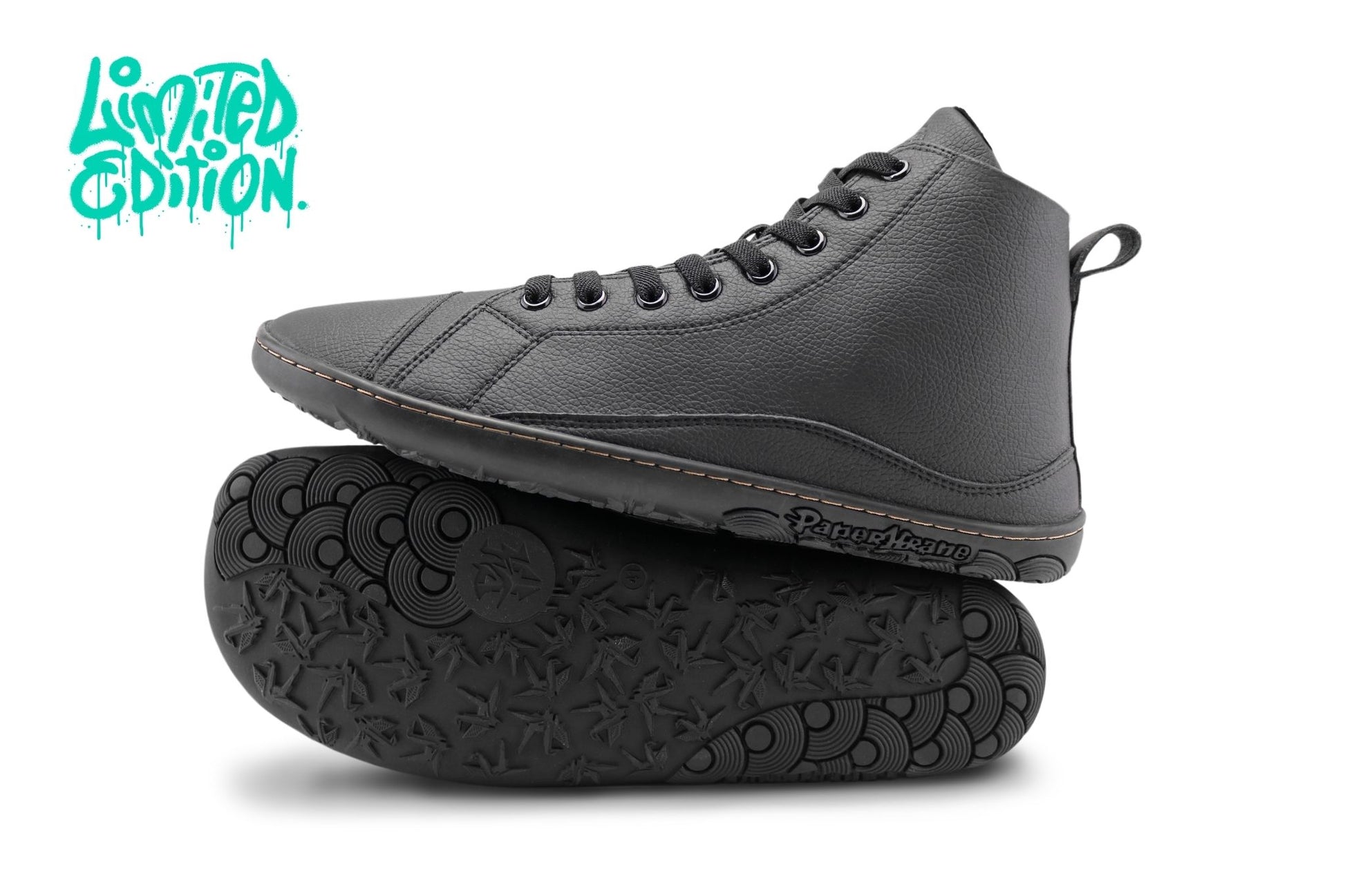 A pair of black vegan leather high-top sneakers, with one shoe standing upright and the other lying on its side to show the treaded sole. The brand name 'PaperKrane' is visible on the side of the sole. There is a teal "Limited Edition" written up in the top left corner. 