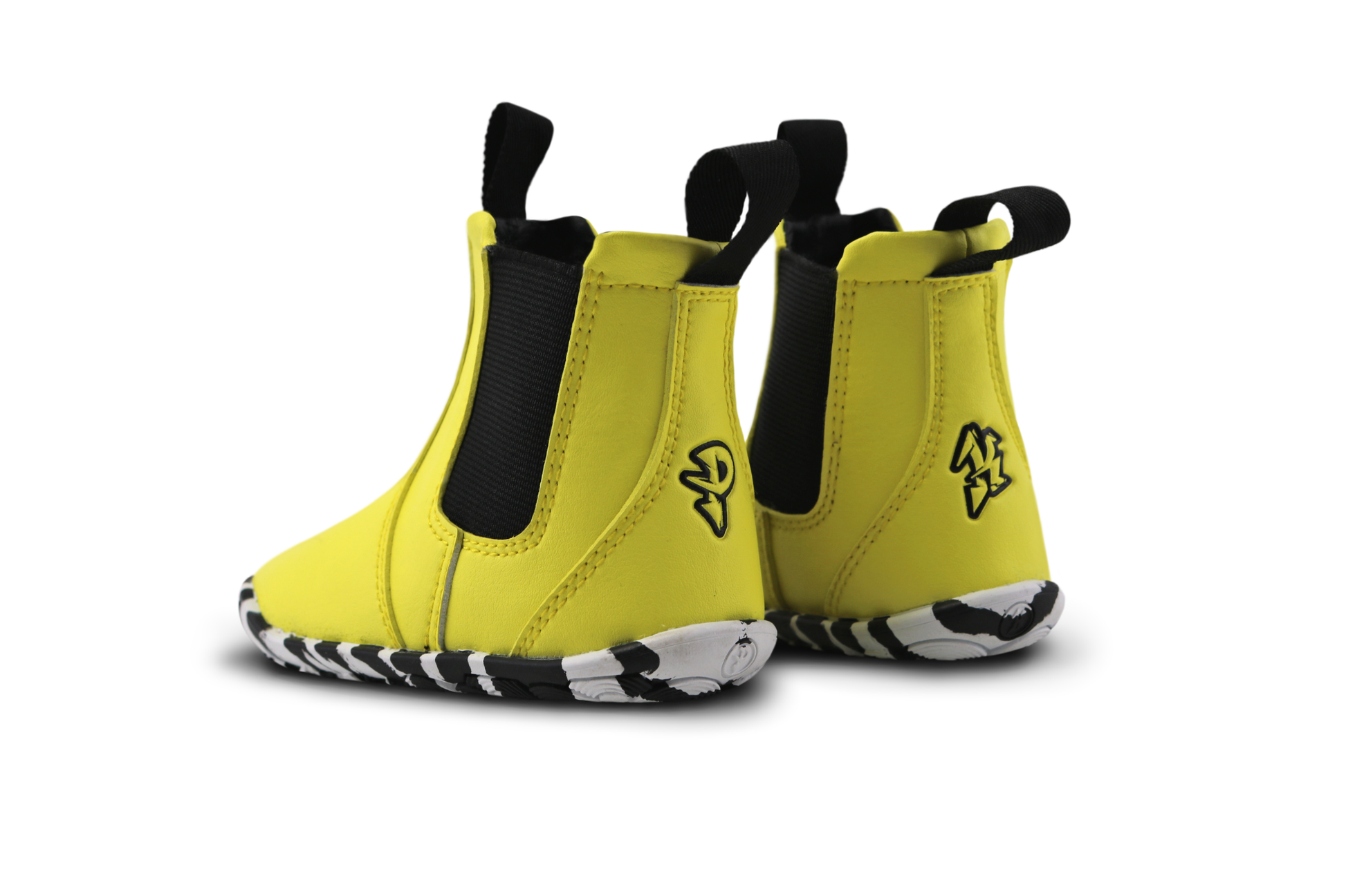 Back view of bright yellow vegan leather midi chelsea boots from PaperKrane. The soles are zebra striped, and the elastic and pull tabs are black. On a white background. 