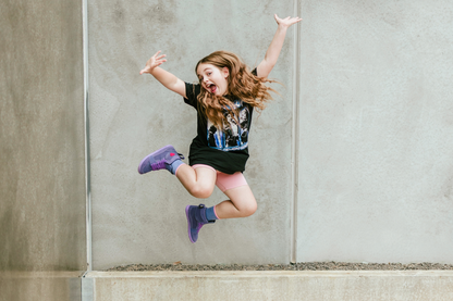 Person jumping in the air against a concrete wall