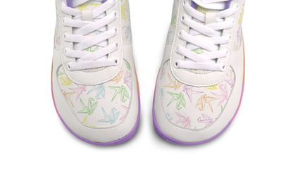 White barefoot sneakers from PaperKrane with a foot-shaped rainbow sole, and rainbow origami cranes printed on them. The lining is purple terry cotton. The view is from above the toe box, on a white background. 