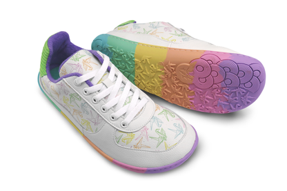 White barefoot sneakers from PaperKrane with a foot-shaped rainbow sole, and rainbow origami cranes printed on them. The lining is purple terry cotton. The view is angled from above, on a white background. 