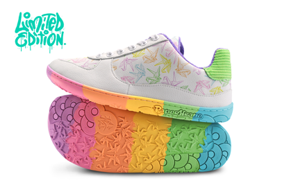White barefoot sneakers from PaperKrane with a foot-shaped rainbow sole, and rainbow origami cranes printed on them. With white background and “limited edition” in the top left corner. 