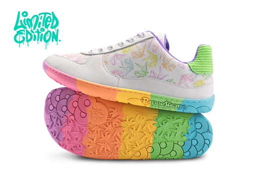White barefoot sneakers from PaperKrane with a foot-shaped rainbow sole, and rainbow origami cranes printed on them. With white background and “limited edition” in the top left corner. 