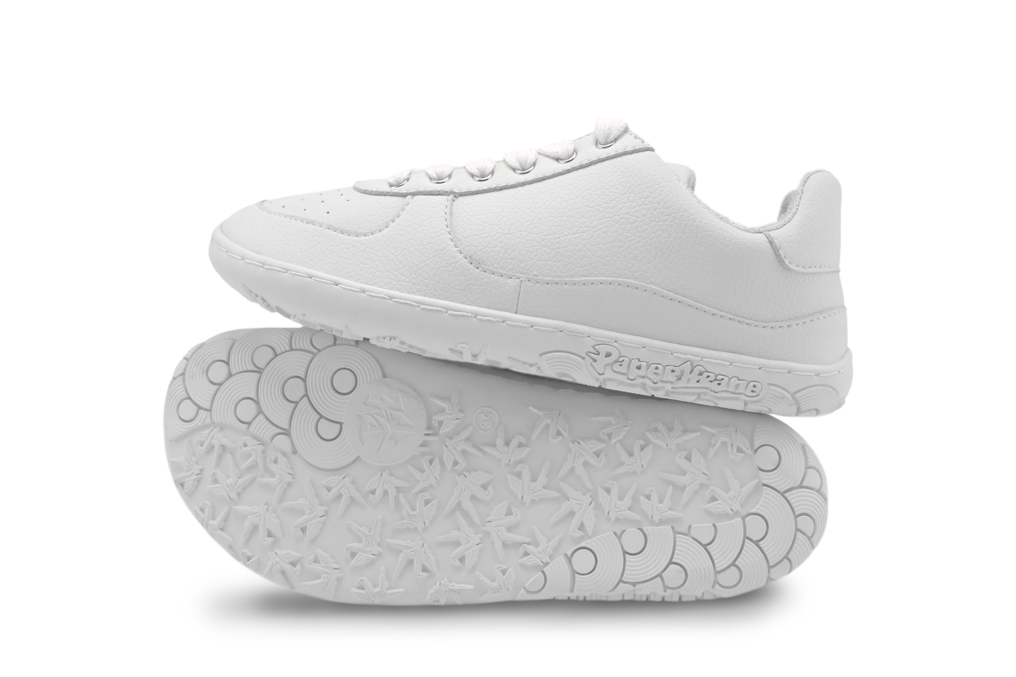 White sneakers with soles facing up on a white background