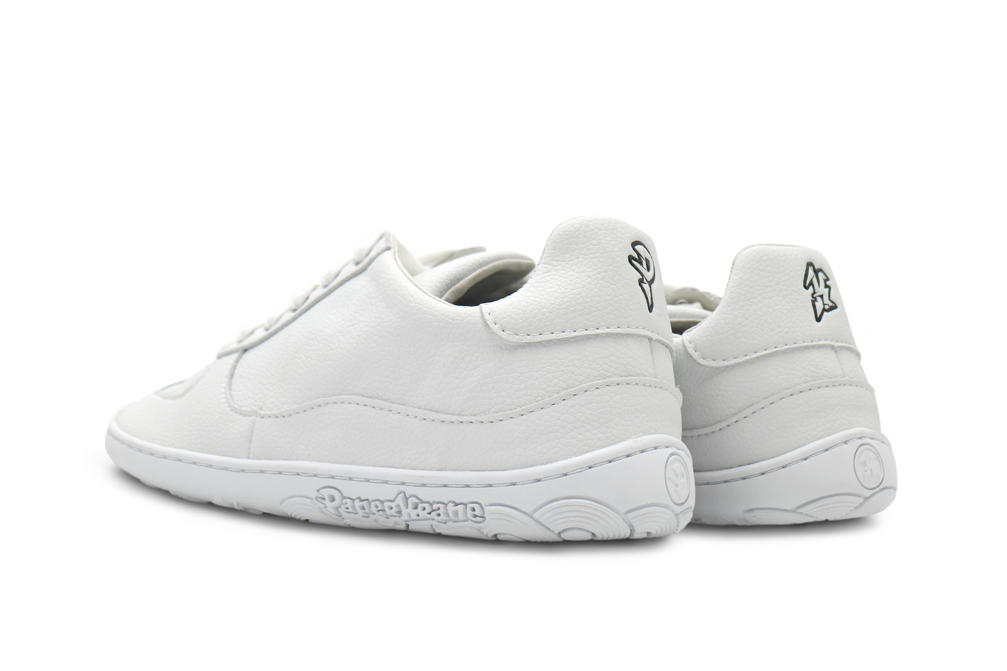 back view of white low barefoot sneakers. The Pand K are in black on the back of the heel. 